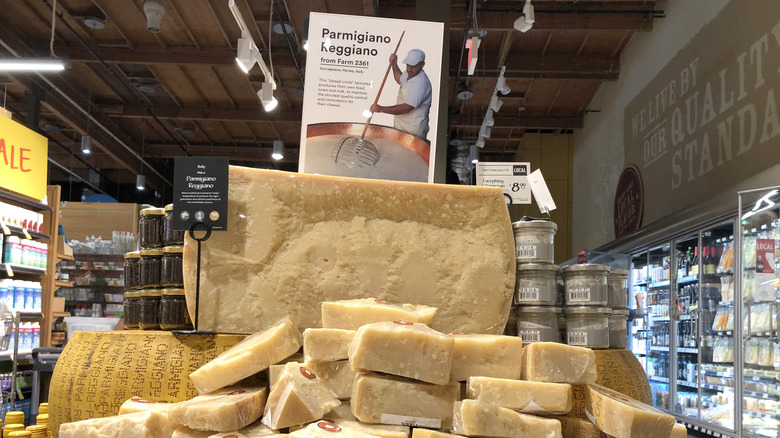 A giant half wheel of Parmigiano Reggiano cheese at a Whole Foods display