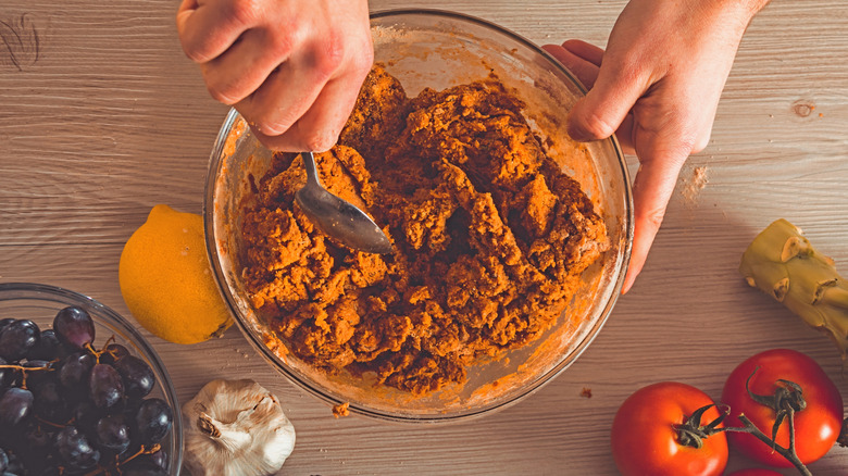 Hands mixing Seitan in bowl