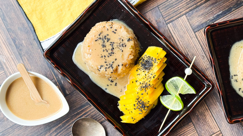 Mango sticky rice and coconut sauce on table