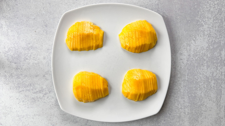 Peeled and sliced mangoes on plate