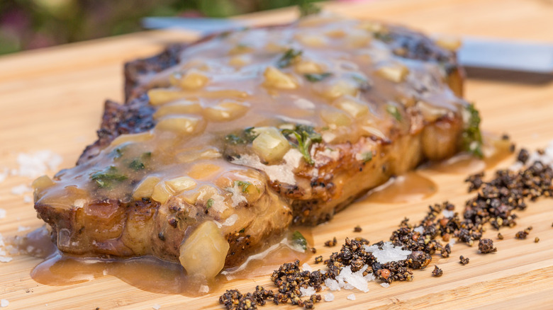 Ribeye steak with Diane sauce on cutting board