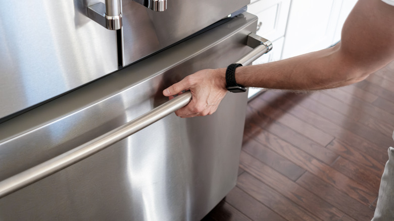 A hand opening a freezer