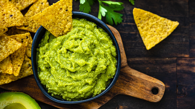 A bowl of guacamole with tortilla chips