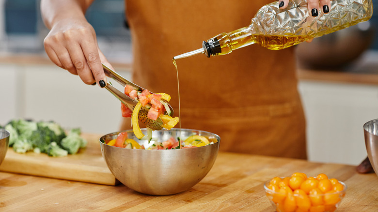 adding oil to vegetables