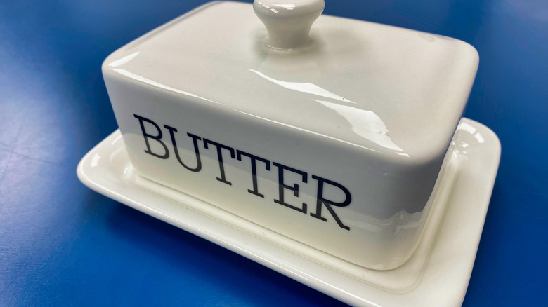 Glass butter dish on blue background