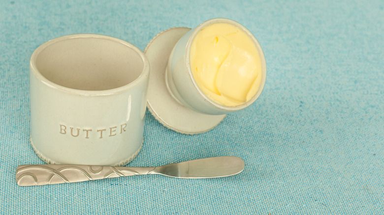 A vintage butter crock on teal cloth backgound