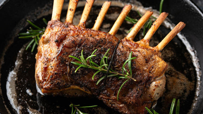 A roasted rack of lamb with the fat on the meat intact.