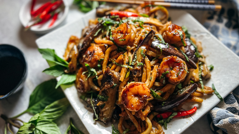 Shrimp and eggplant stir-fry on plate with garnishes