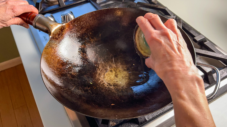 Adding oil to wok on stove