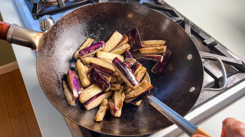 Sauteed Chinese eggplant in wok on stove