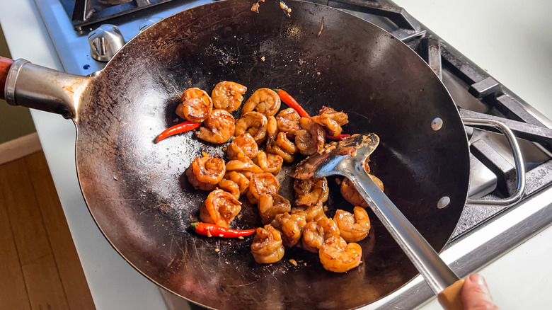 Sauteed shrimp and Thai chiles in wok on stove