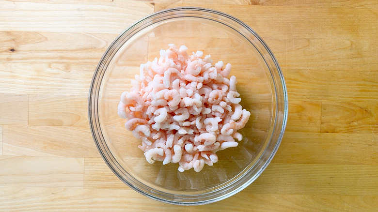 Salad shrimp in glass bowl on cutting board