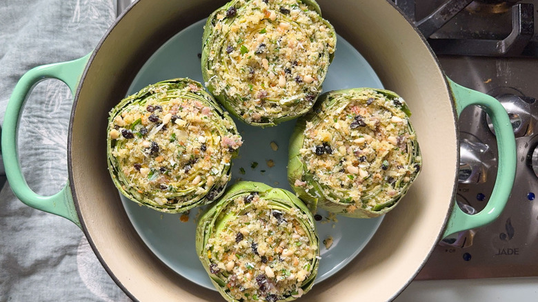 Sicilian-style stuffed artichokes on plate in steam bath on stovetop