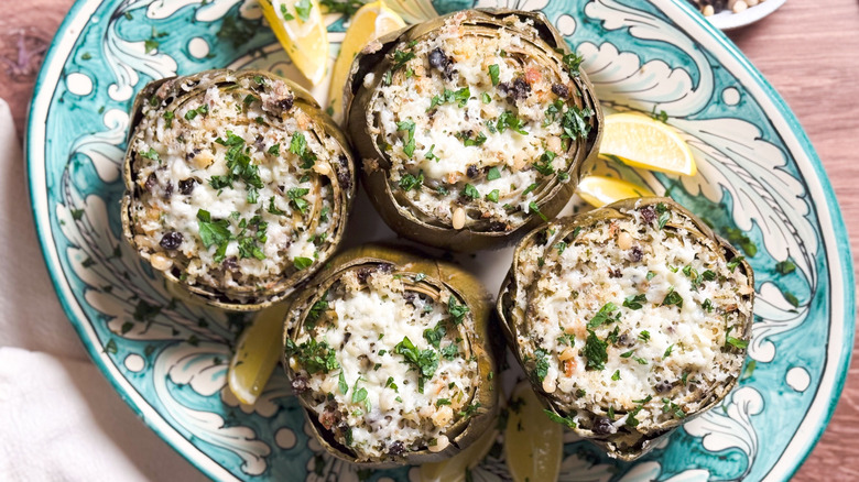 Sicilian-style stuffed artichokes on serving platter with lemon wedges