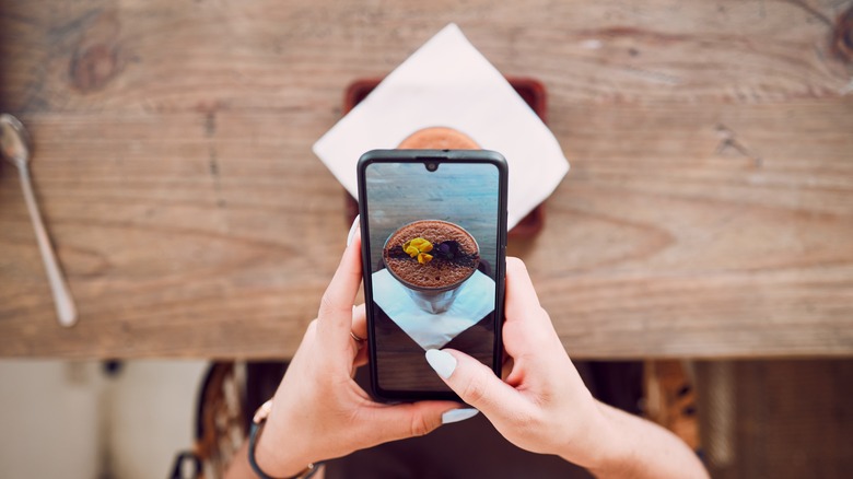 woman taking photo of dessert