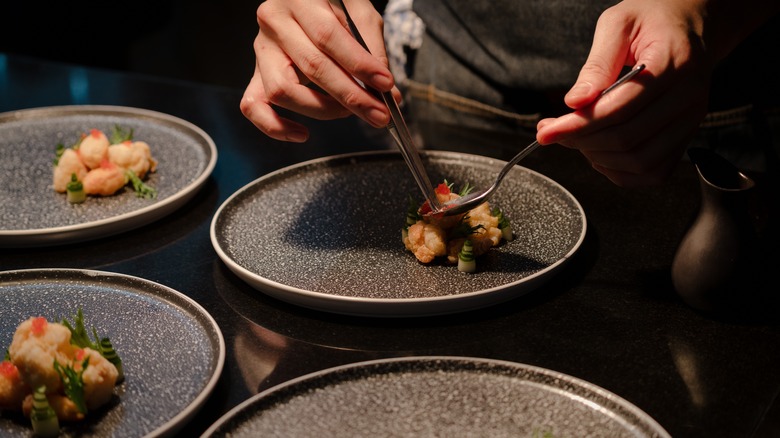 chef placing food on plate