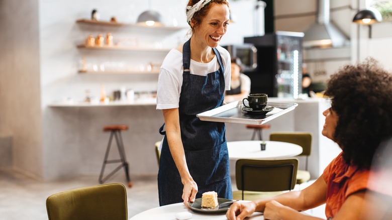 Female server smiling with coffee