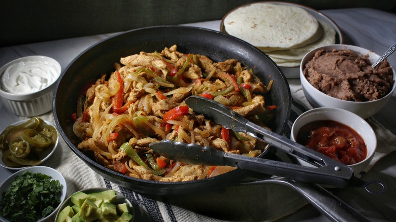skillet of fajitas with garnishes