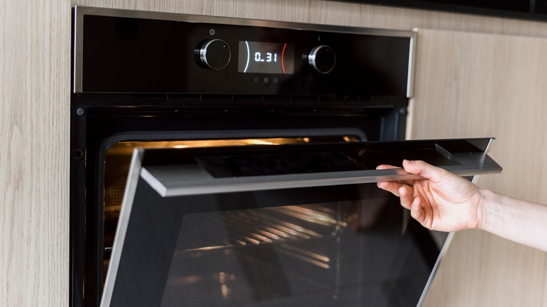 Woman's hand opening oven door