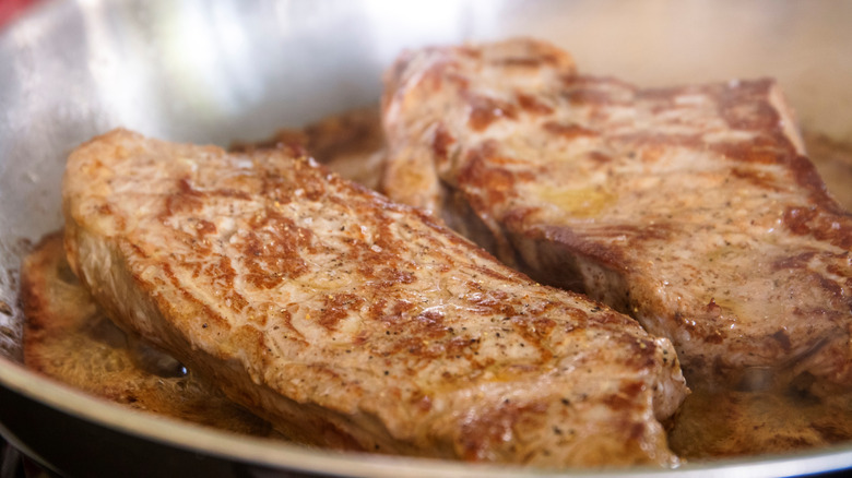 sizzle steaks cooking in pan