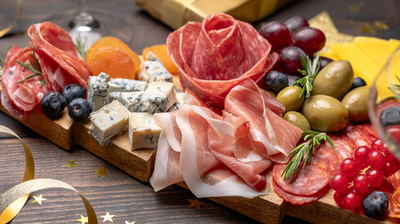 Charcuterie board with meats, cheese, and fruits