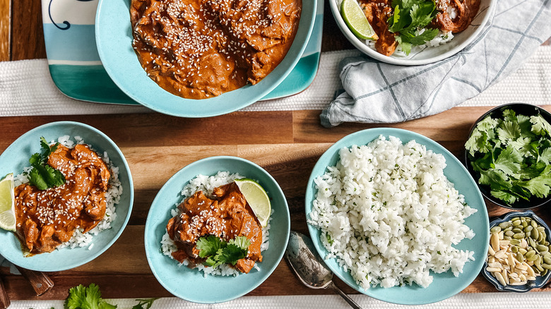 Slow cooker chicken mole served on table with rice and garnish