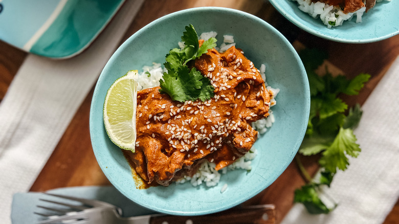 Slow cooker chicken mole in bowl with garnish