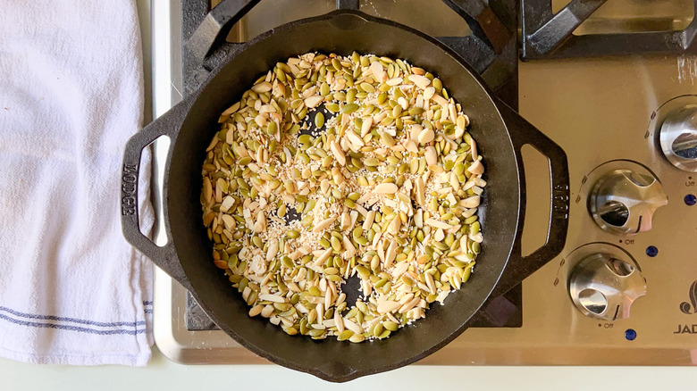 Almonds, pepitas, and sesame seeds in cast iron skillet