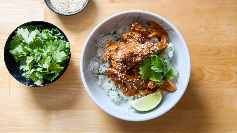 Slow cooker chicken mole over rice with garnish in bowl