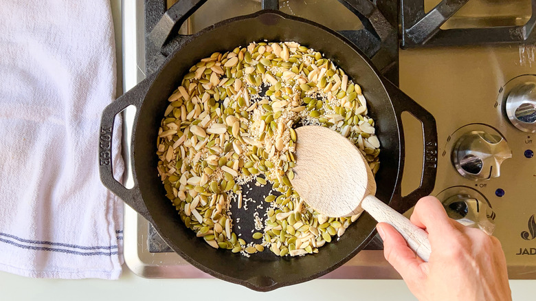 Toasting almonds, pepitas, and sesame seeds in skillet