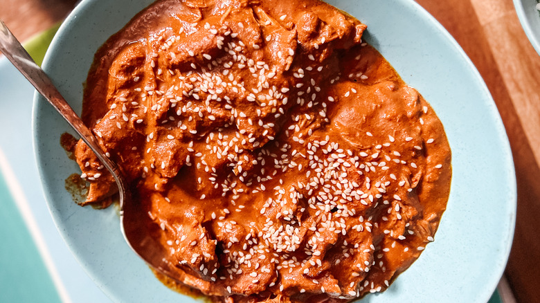 Slow cooker chicken mole with sesame seeds in bowl