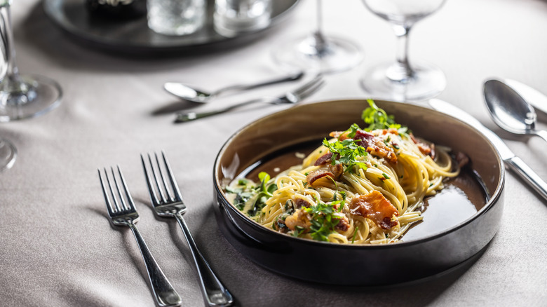 Spaghetti carbonara on well-set dinner table