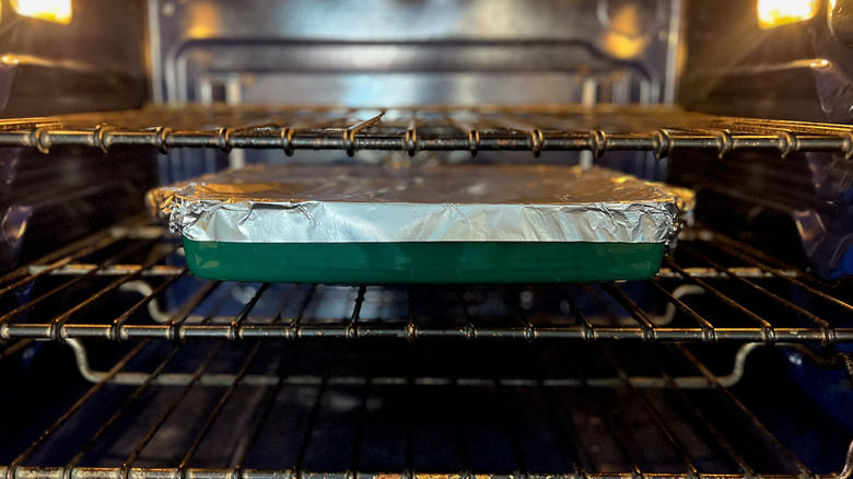 Foil covered pan in oven