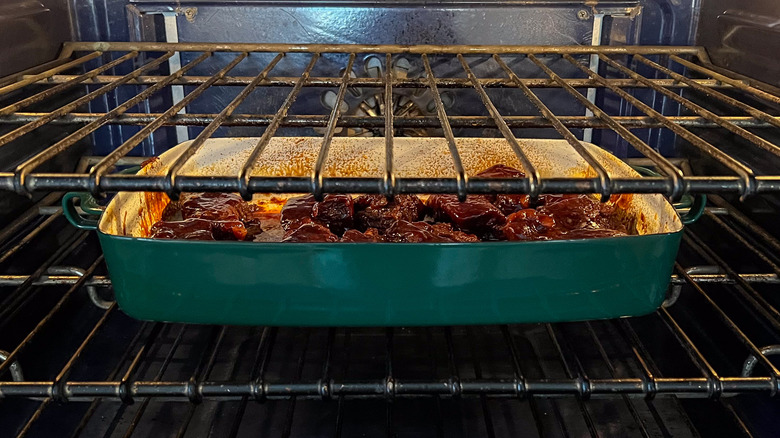 Beef short ribs in pan with barbecue sauce in oven