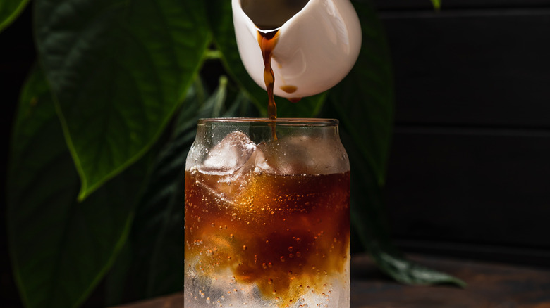 espresso being poured over a bubbly clear beverage