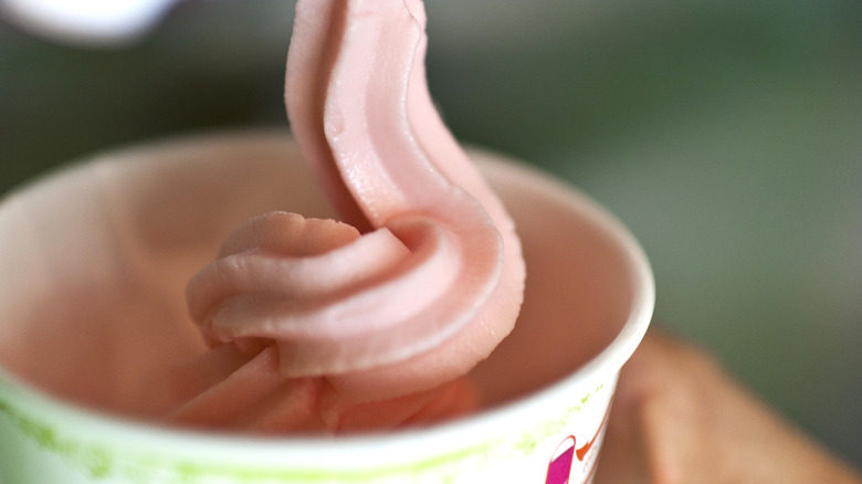 strawberry soft serve being dispensed into cup