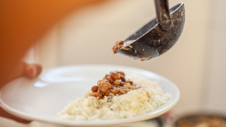 Person plating rice and beans with a ladle