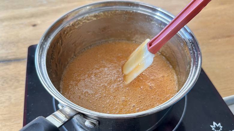 Bubbling candy mixture with spatula in pot