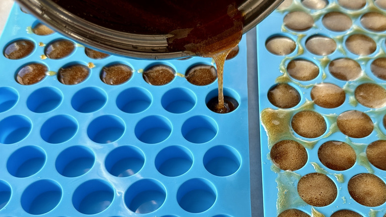 Hot candy mixture pouring into blue molds