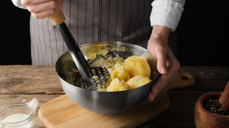 woman mashing potatoes by hand