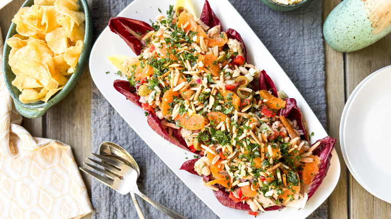 Spanish-inspired tuna salad with white beans and oranges on serving platter on table with potato chips