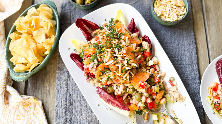 Spanish-inspired tuna salad with white beans and oranges on serving platter with potato chips and slivered almonds