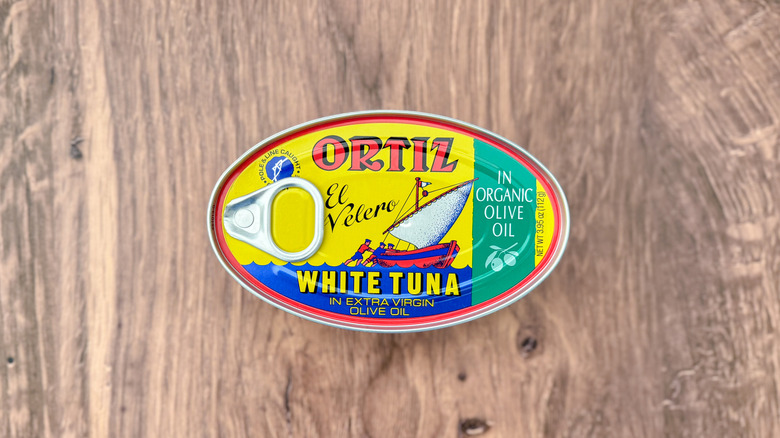 Can of Ortiz white tuna in organic extra virgin olive oil on cutting board