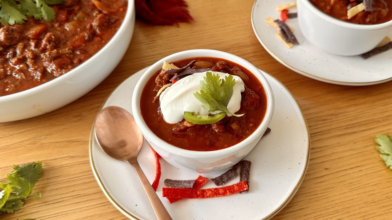 spicy chili with sour cream topping in bowl