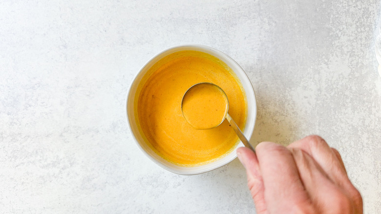 Spooky pumpkin curry Halloween soup in bowl with ladle