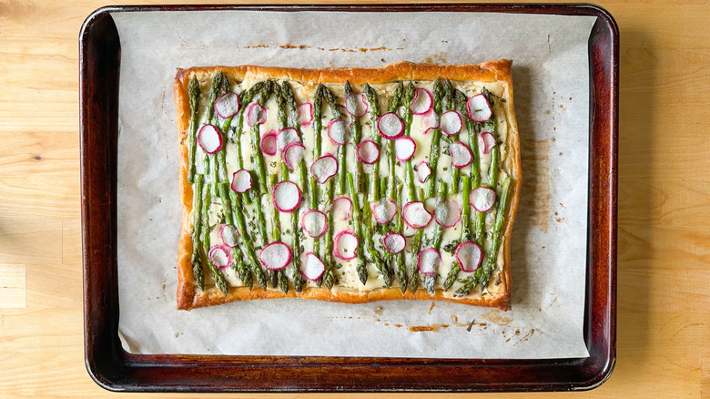 Springy asparagus and lemon ricotta tart cooling on baking sheet