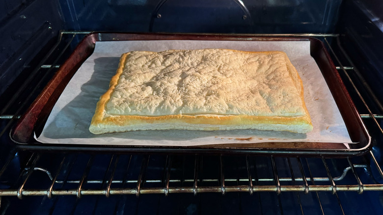 Baked puff pastry in oven on parchment paper on baking sheet