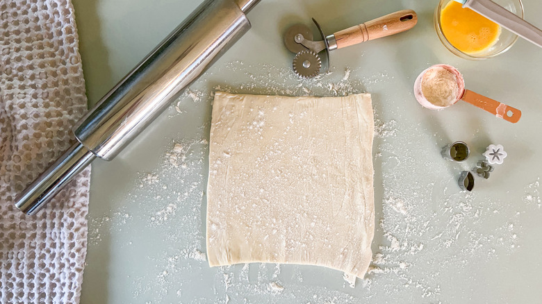 Puff pastry on floured counter top with rolling pin and cutters