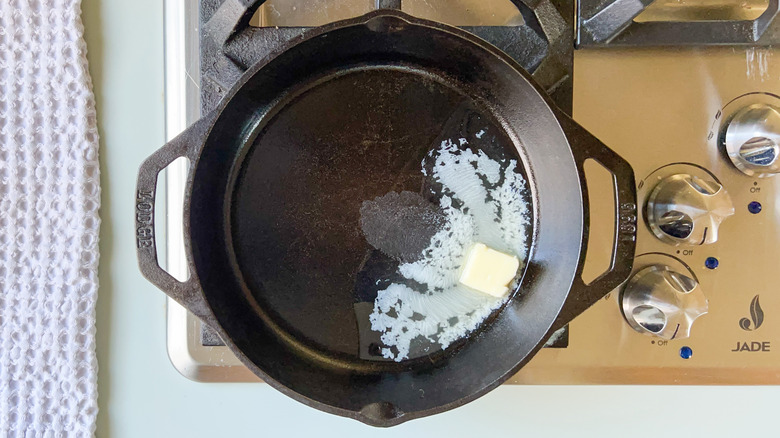 Butter melting in cast iron skillet on stovetop