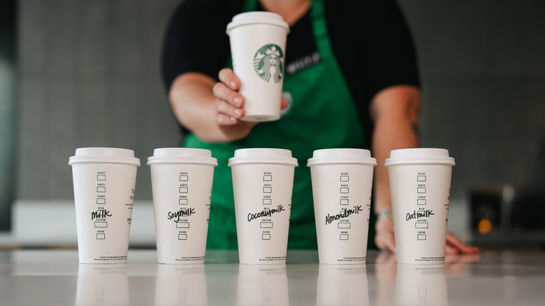 A row of Starbucks cups labeled with different milks